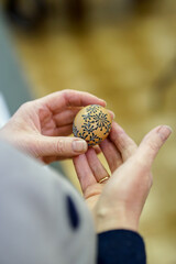 Woman hands painting Easter eggs with black bee wax, traditional Lithuanian method