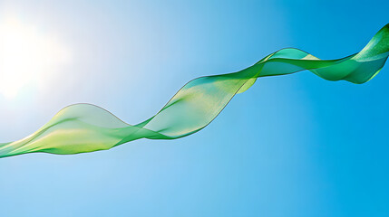 A translucent green wave-like ribbon floating against a clear blue sky with the sun shining in the background