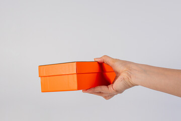 Orange box in hand isolated on white background 