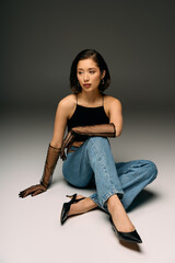 Elegant young woman showcasing modern fashion in a minimalist studio setting