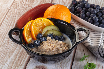 Oats porridge with blueberry, kiwi and orange