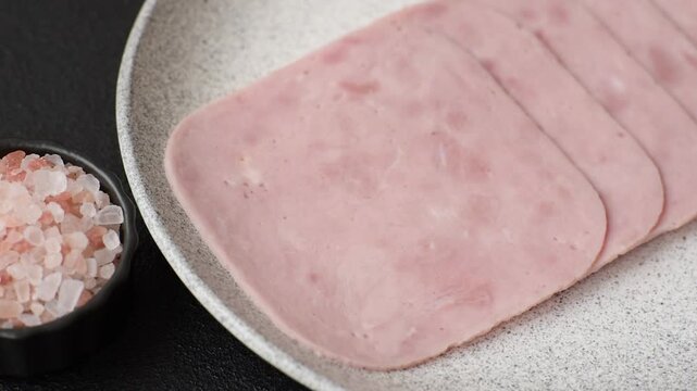 Eating ham and pork slices for the holiday table. Spiced ham sliced for breakfast sandwiches