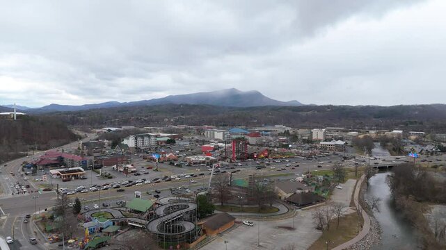 Aerial shot pulling out from Piegon Forge, TN on January 1st 2025 with snow covered Smoky Mountains in the background.