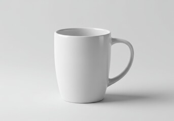 Obraz premium Simple white ceramic coffee mug placed on a plain gray background in studio lighting setting photo