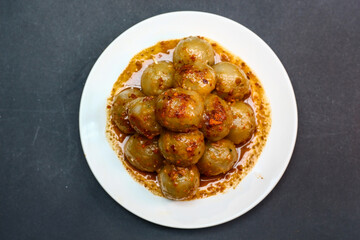 Cilok is a typical West Javanese food, made from tapioca flour and served with chilli sauce. It has a round shape like meatballs, isolated on a black background. Selective focus