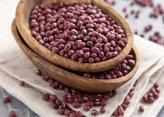 Bowls full of dried azuki beans on gray closeup. Vegetarian protein source, East Asian legumes