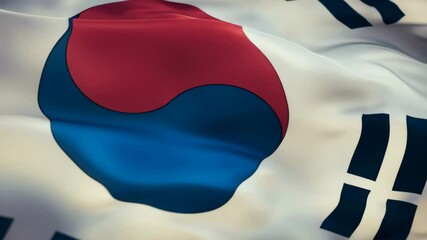 A close-up of a waving South Korean flag, featuring a central taegeuk symbol and four trigrams.