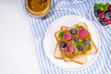 Pistachio paste toast. Summer breakfast delicious sandwiches with pistachio butter spread, with fresh berries. Balanced healthy vitamins and macronutrients snack