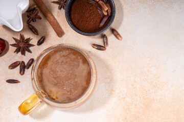 Healthy organic date seed coffee, coffee latte cup, made with grated date seeds, with whole date fruits and seeds on beige background . Alternative coffee hot drink