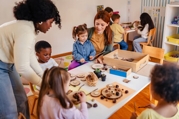 Curious preschool children explore nature objects with a teacher during a hands-on science activity in a diverse classroom setting
