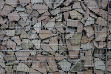 Collection of irregular stone pieces held in a wire mesh, used for landscaping and building...