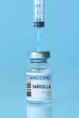 Varicella vaccine bottle and syringe placed on a clean blue background, representing healthcare, medical science, immunization awareness, and disease prevention. Banner with copy space