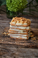 Napoleon of homemade puff pastry. Wooden background.