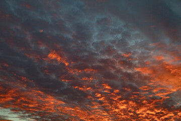 Spectacular sunset paints the sky with fiery orange and deep blue clouds creating a beautiful view.