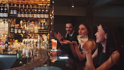 Couple talking at sitting bar with Margarita cocktail savoring sour tasty drink in happiness moment meeting while woman waiting friends at front view at luxurious counter vibrant nightclub. Vinosity.