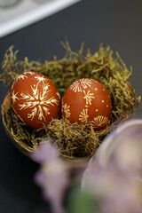 Woman hands painting Easter eggs with black bee wax, traditional Lithuanian method