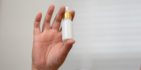 Serum and Skincare and Personal Care. A hand holding a beauty serum dropper, highlighting the essentials of skincare in a beauty routine.