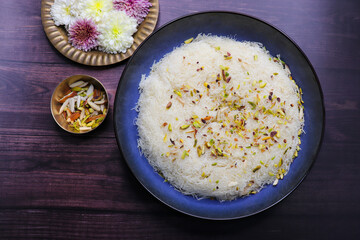 Closeup of Sutarfeni, a traditional Indian sweet made from fine sev soaked in sweet saffron flavored milk, garnished with dry fruits. perfect for festive celebrations and Indian cuisine themes. copy