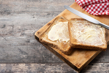 Sliced fresh bread and butter on wooden table. Copy space