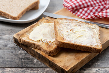 Sliced fresh bread and butter on wooden table
