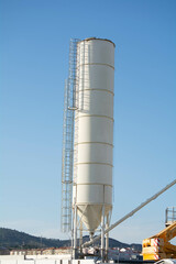 Silos used for storing materials in a construction site under a clear blue sky