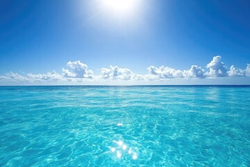 Obraz premium A serene view of turquoise ocean water meeting a brilliant blue sky.