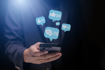 Close-up of man's hand using smartphone to play social media with emoticons or notifications popup.	
