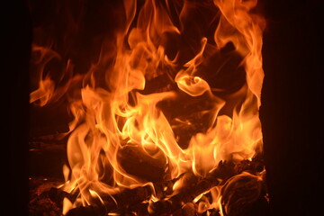 Bright flames dance vividly in a fireplace creating warmth and comfort during a chilly evening indoors