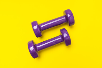 Dumbbells for fitness, sports on yellow background. Concept of healthy lifestyle, wellness, sports equipment for beautiful figure, top view flat lay