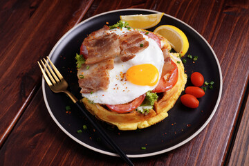 Fried Egg and Pork Waffles Food in a black plate on a wooden table