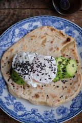 Flatbread with with avocado, poached egg and black sesame