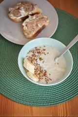 Rice pudding with banana and seeds. wooden background, side view