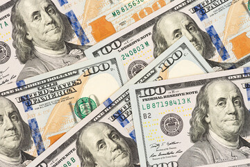 Scattered US hundred dollar bills with Benjamin Franklin portrait. Flat lay composition of American banknotes for finance and investment concept.