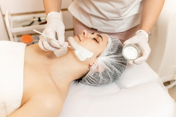 Shot of a beautiful young woman getting a facial mask treatment at the beauty salon