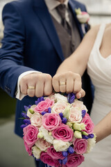 Romantische Hochzeitsdetails – Braut und Bräutigam mit Blumenstrauß und Eheringen