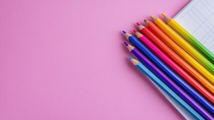 Obraz premium Colorful Pencils on Pink Background with Grid Paper for Creativity