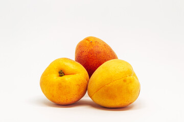 Three ripe peaches are piled on top of each other