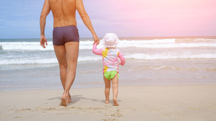 Naklejka premium Father and daughter walking on tropical beach