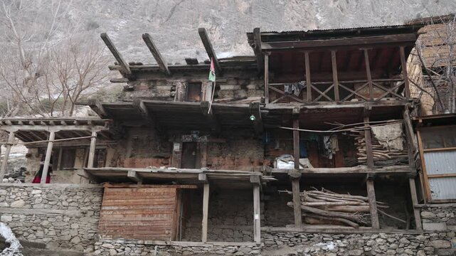 Kalash Valley Traditional Buildings in WInter. Traditionally Dressed Young Girl in Bumburet Valley, Chitral, Pakistan.