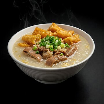 bowl of Vietnamese  chao long (pork offal porridge) with scallions and fried dough on black background  