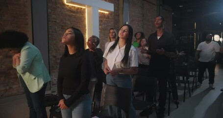 People standing and worshiping in church, eyes raised to the illuminated cross, Christian faith, spiritual moment, prayerful expressions, diverse group in devotion