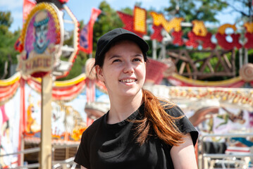 Joyful day at the amusement park with carnival rides. Young woman.. Happy summer days, travel and vacation concept