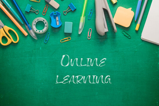 Green chalkboard with a variety of school supplies - Powered by Adobe