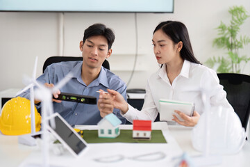 Renewable Energy and Engineering. Engineers collaborate to design green solutions, focusing on mini models of eco-friendly houses and wind turbines.