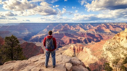 Fototapeta premium A traveler standing at the edge of the Grand Canyon, marveling at the vast, dramatic landscape.