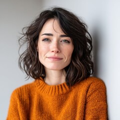 Fototapeta premium smiling depression smiling face silence concept. Smiling woman with wavy hair in a cozy sweater against a neutral background.