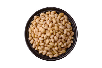 Peeled pine nuts in a bowl on a white background