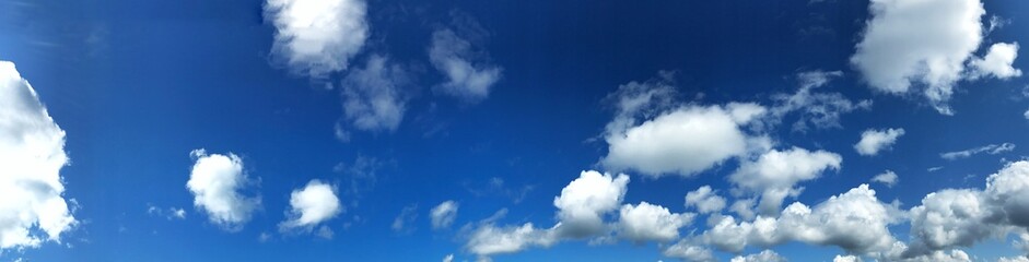 Panoramic view of a blue sky with fluffy white clouds