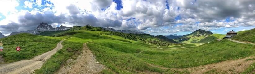 Scenic mountain panorama with green hills and cloudy blue sky