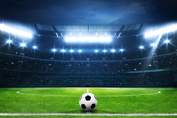 Football stadium full of fans, grass pitch and with spotlights on. Sport building
